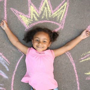 girl laying on the ground with chalk crown