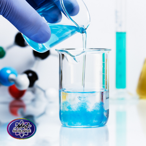 Stock photo of gloved hands pouring blue liquid into a science bottle