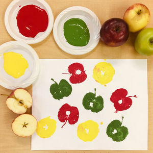 Red, yellow, green paint with cut apples and apple print 