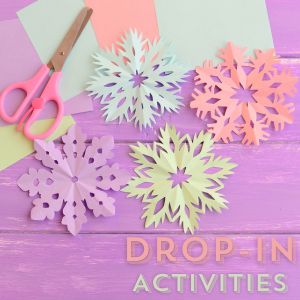 Pastel colored paper and cut snowflakes with scissors