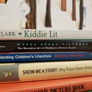 Stack of Critical Books about Picturebooks, original photo; Background image from A Child of Books by Oliver Jeffers 