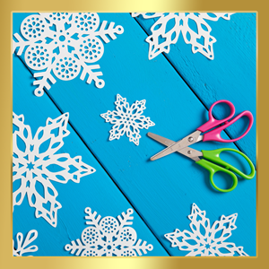 Crossed green and pink scissors against a bright blue background, with paper snowflakes scattered around