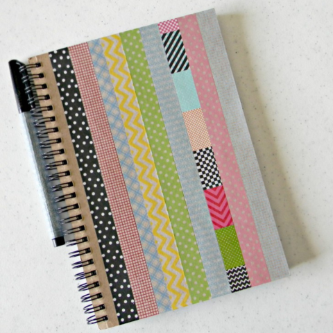 A spiral-bound journal with the cover decorated with washi tape.