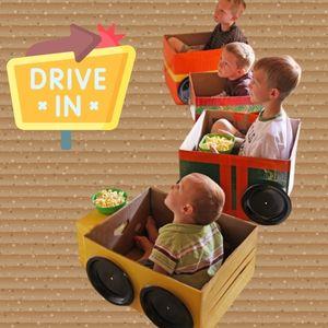 Children sitting in cardboard box "cars" watching a movie