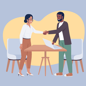 Two professionals shake hands across a table.