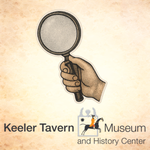 Hand holding magnifying glass with Keeler Tavern Museum logo