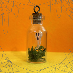 An image of a ghost in a small jar with some moss, against a yellow and orange background